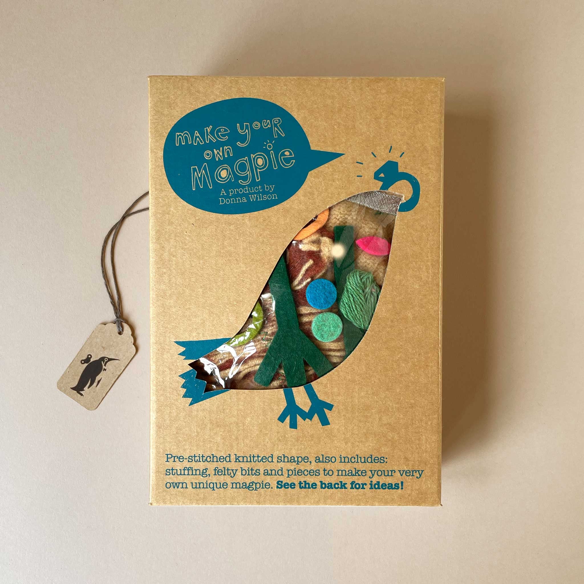 Cardboard box with bird design and text 'Make your own Magpie' on a beige background