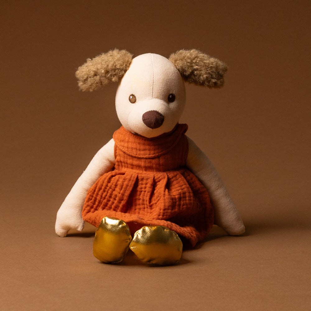 amy-the-puppy Stuffed animal toy dog wearing an orange dress on a brown background