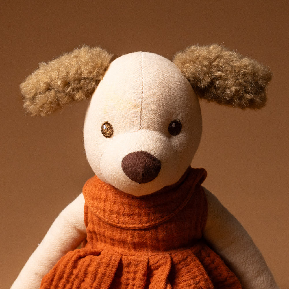 amy-the-puppy Stuffed animal toy with a orange dress on a brown background