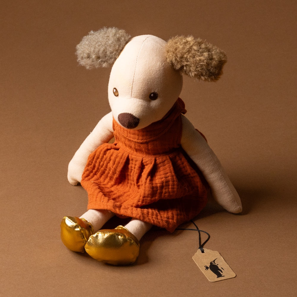 amy-the-puppy Stuffed animal toy with a orange dress and gold shoes on a brown background