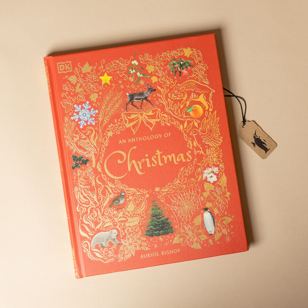Book titled 'An Anthology of Christmas' with red cover with foil writing and christmas images decorative cover on a beige background