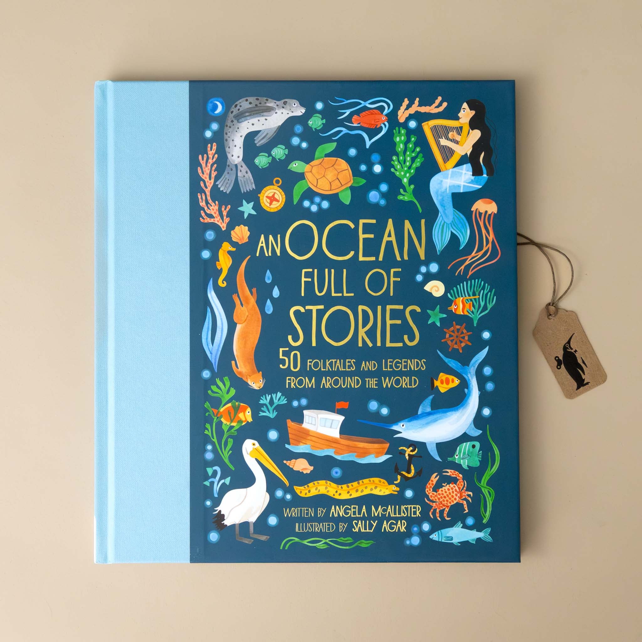 an-ocean-full-of-stories-book-blue-cover-with-mermaids-sea-creatures-and-sea-life