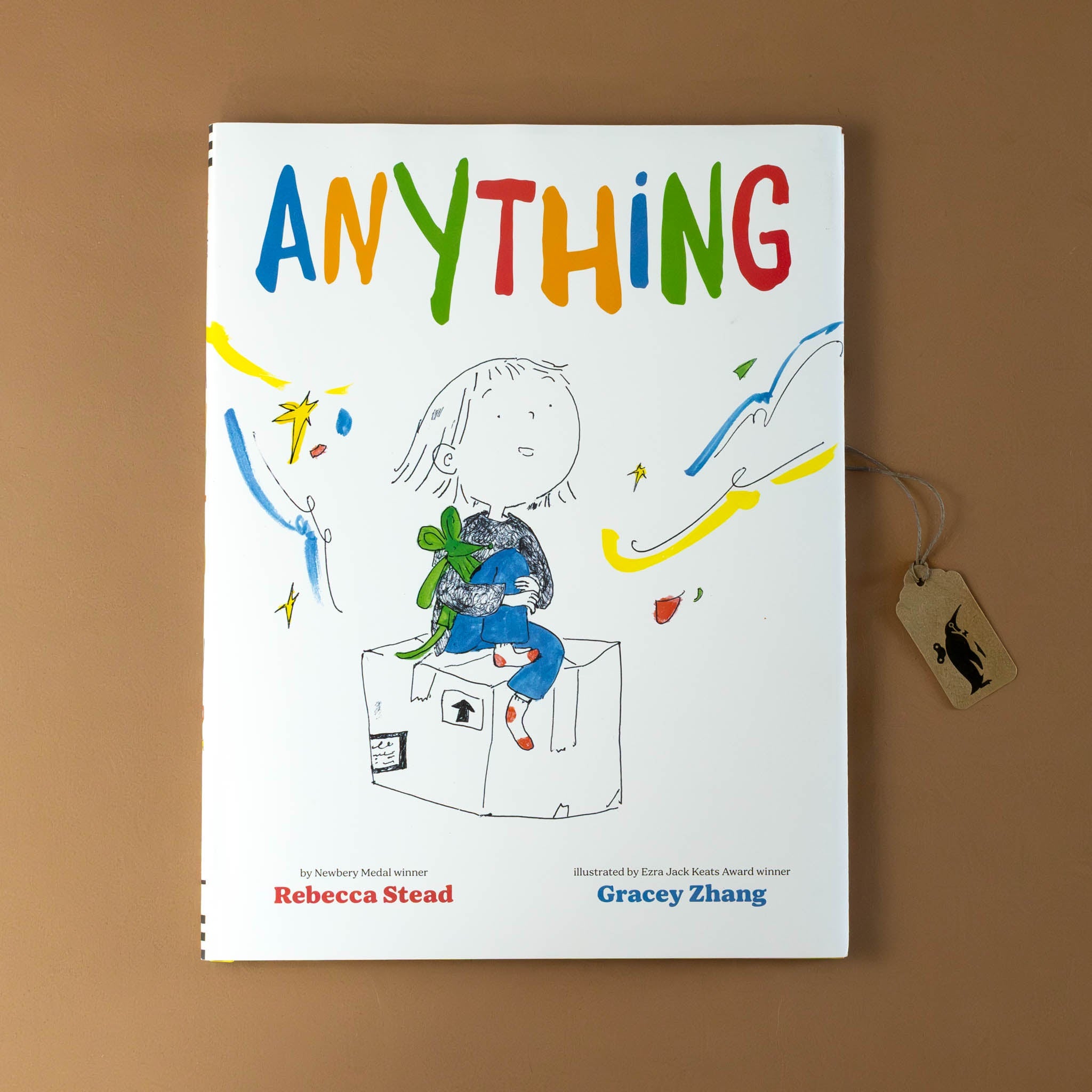 anything-book-cover-with-a-girl-sitting-on-moving-box-with-sparkles-around