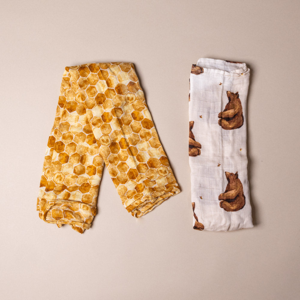 bamboo-burpie-set-honey-bear with honeycomb pattern and a burp cloth with bear design on a beige background