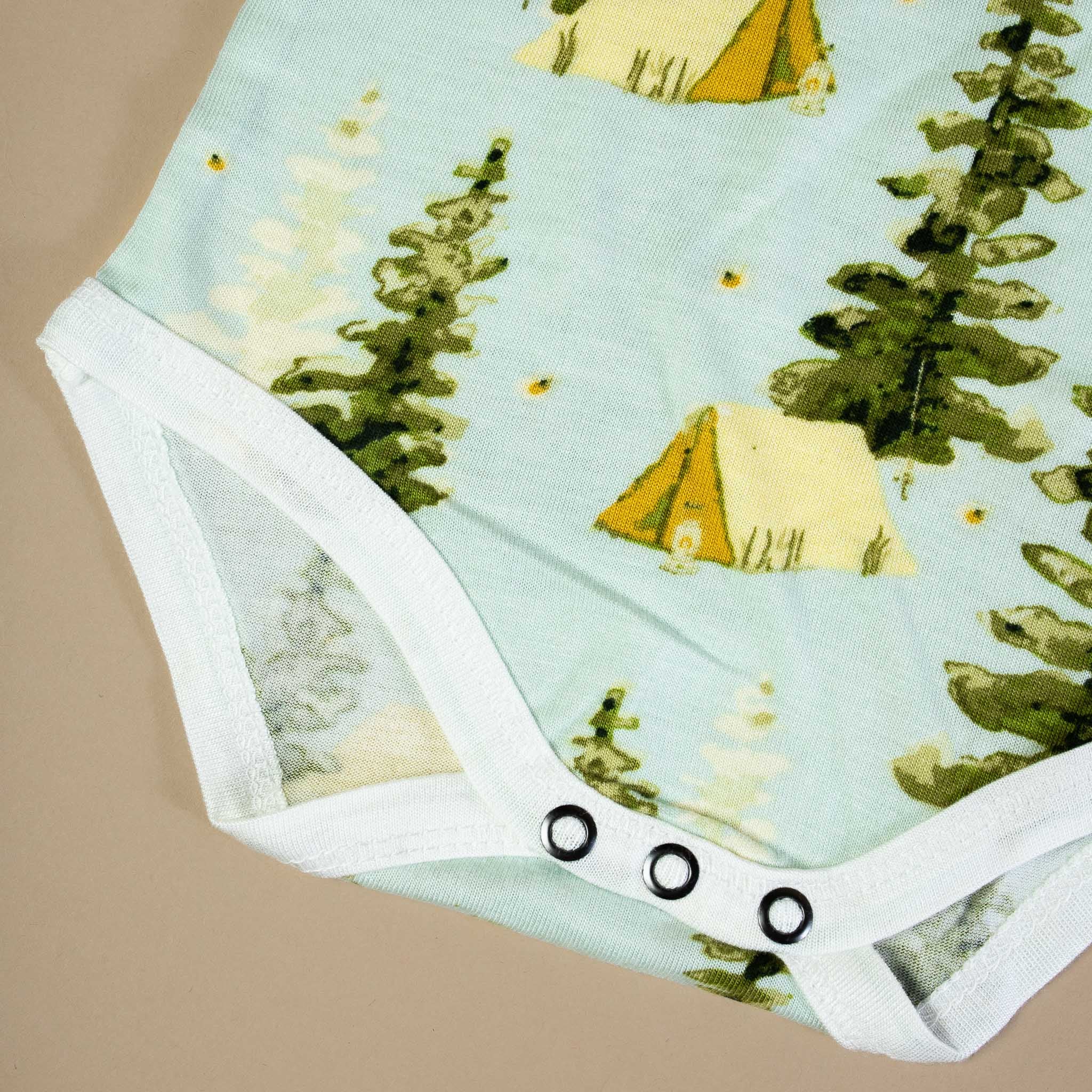 bamboo-long-sleeve-onesie-camping Baby onesie with camping design featuring tents and trees on a light blue background.