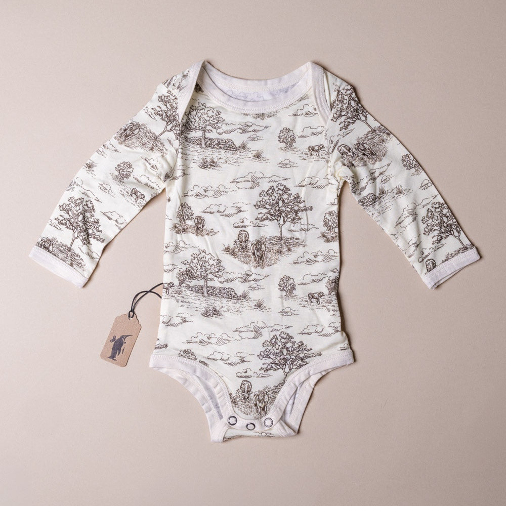 bamboo-long-sleeve-stretch-onesie-meadow-toile-6-12months Baby onesie with nature print on a beige background
