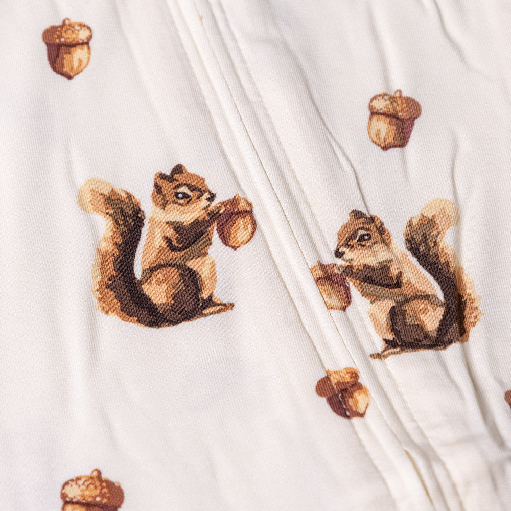 bamboo-stretch-zipper-pajamas-chipmunk Close-up of a white fabric with brown chipmunk and acorn patterns.