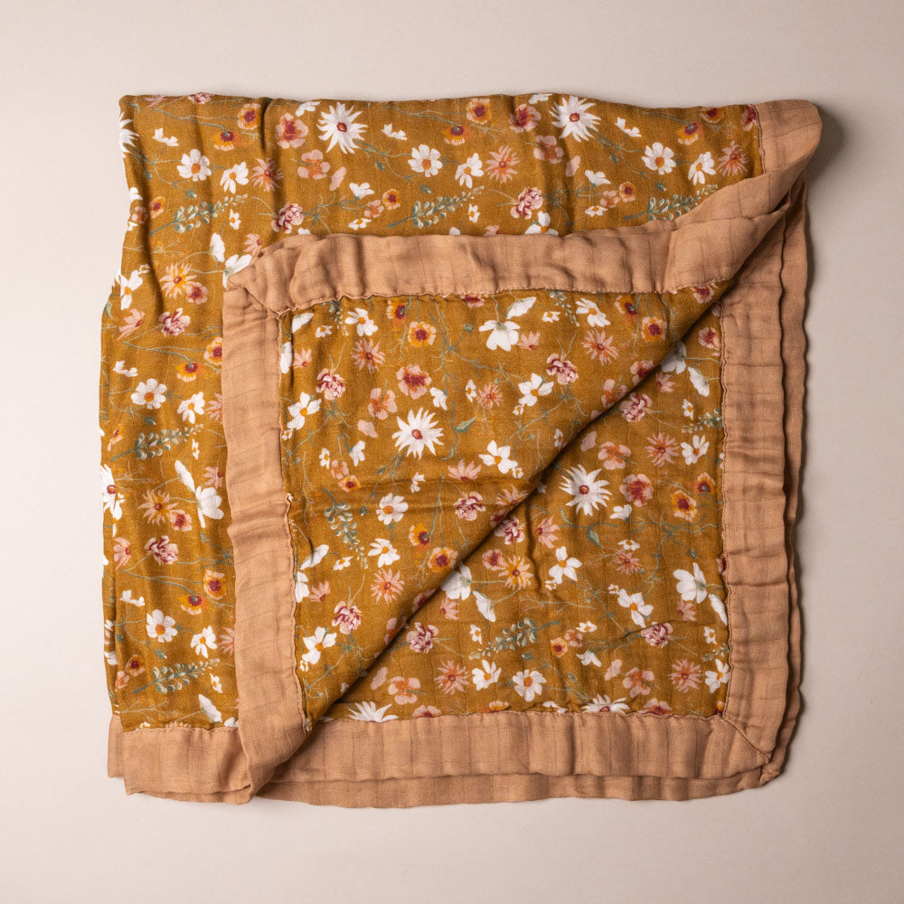big-lovie-wildflower Floral patterned blanket with brown border on a beige background
