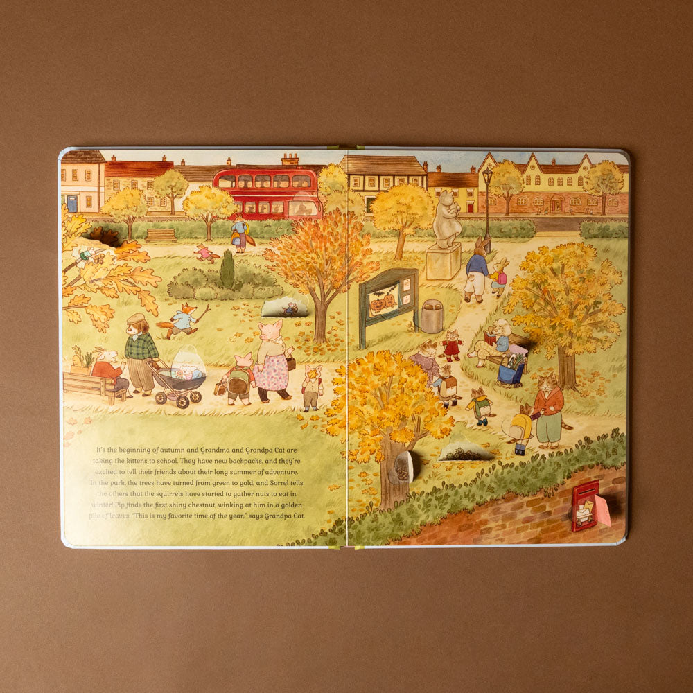 cat-family-four-seasons-life-the-flap-book Illustrated children's book page with autumn scene and characters on a brown background
