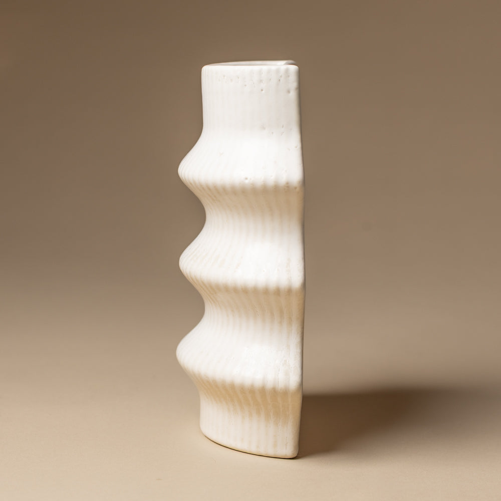 claude-bookend-vase-ripple White textured vase on a beige background