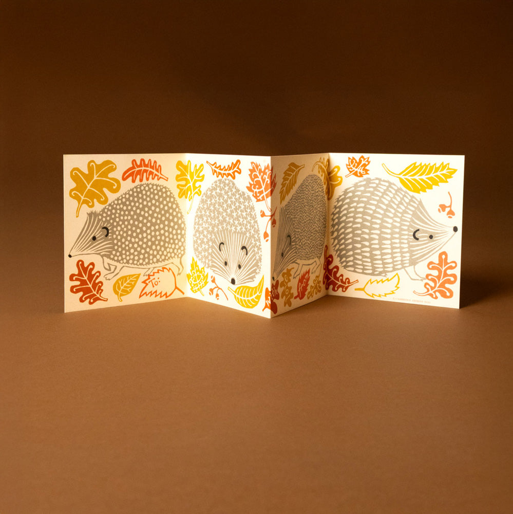 Folded concertina-greeting-card--prickle-of-hedgehogs illustrations on a brown background