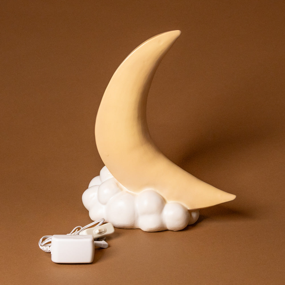 yellow Crescent moon-shaped lamp with cloud base on a brown background
