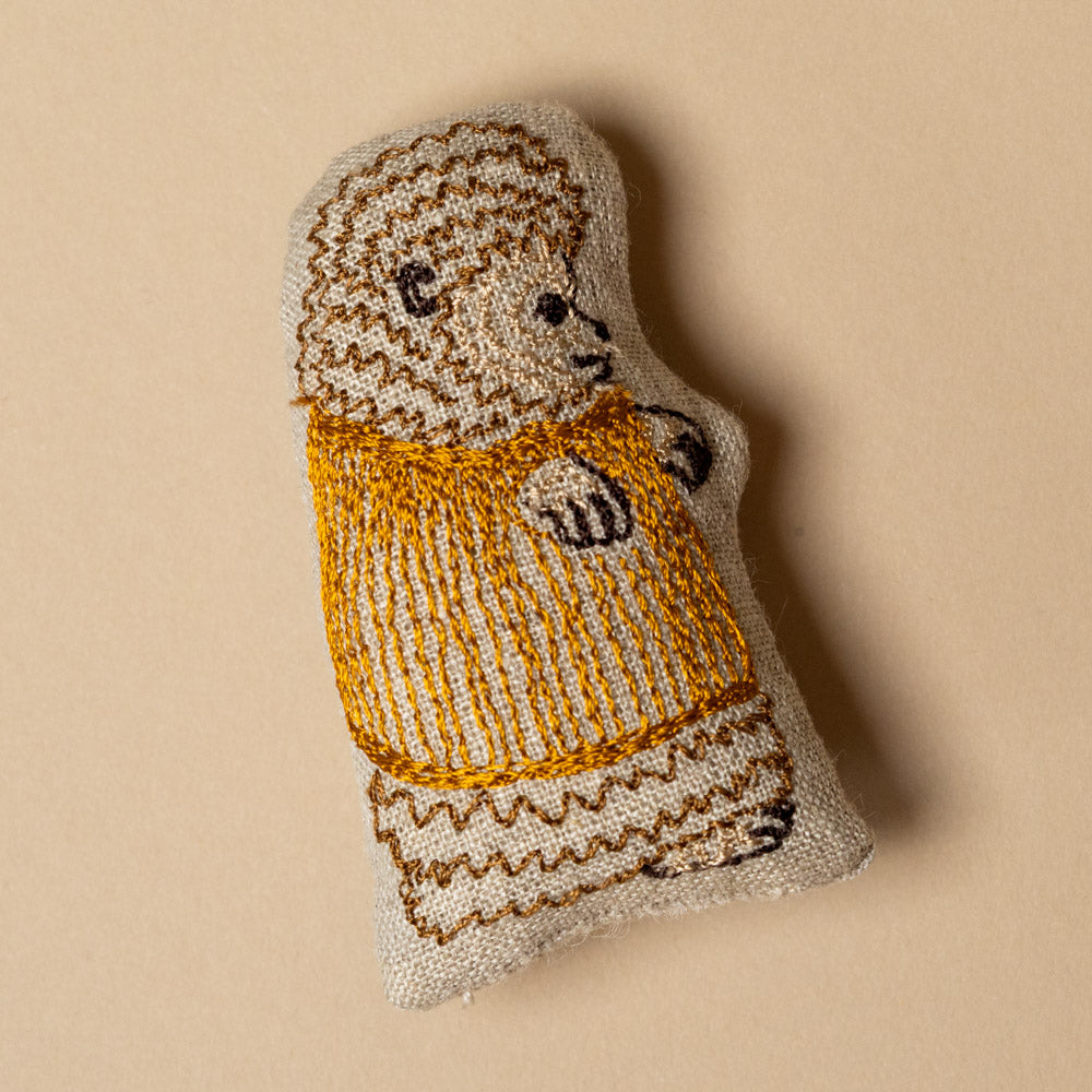 embroidered-pocket-pillow-tandem-bike-buddies hedge hog pocket pall with a yellow sweater on a beige background