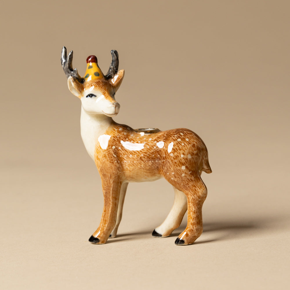 heirloom-porcelain-cake-topper-stag Deer figurine with a party hat on a beige background