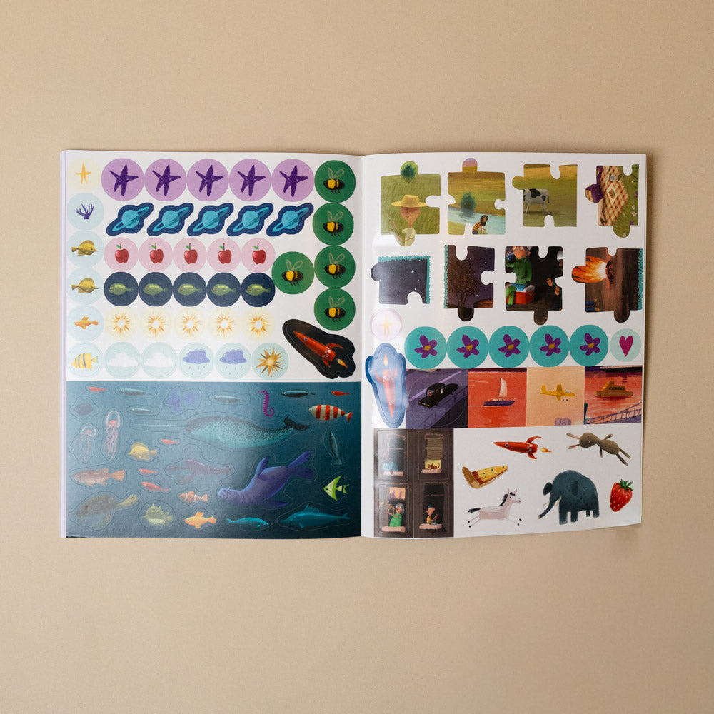 here-we-are-activity-book Open book with colorful stickers on a beige background