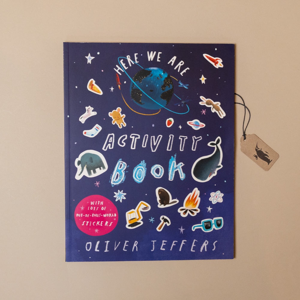 Activity book titled 'Here We Are' by Oliver Jeffers with stickers on a beige background