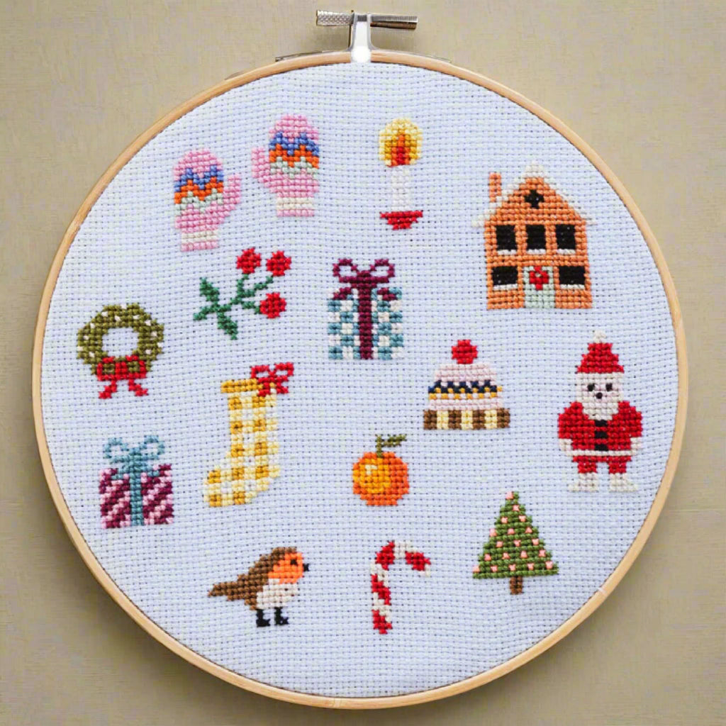 holiday-cross-stitch-kit--beginner Christmas-themed design in an embroidery hoop on a light blue background