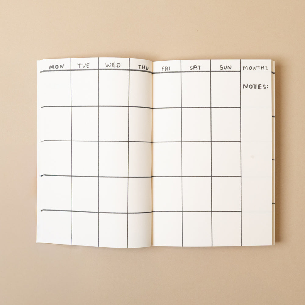 Foldable life-is-happening-planning-journal with grid layout on a beige background