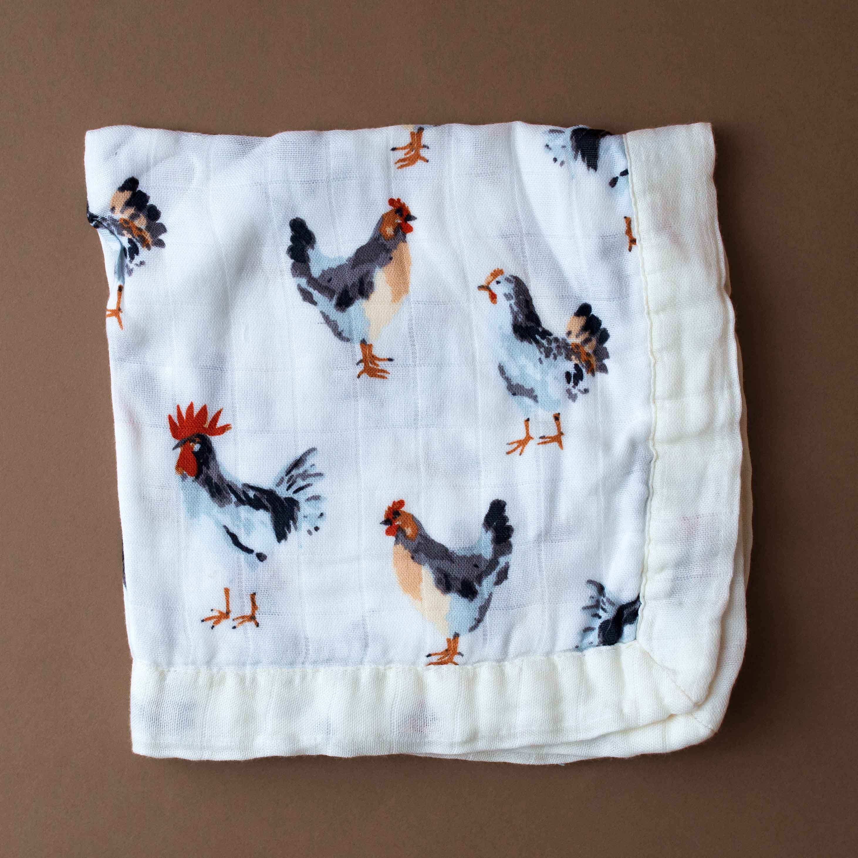 little-lovie-chickens Folded fabric with chicken pattern on a brown background