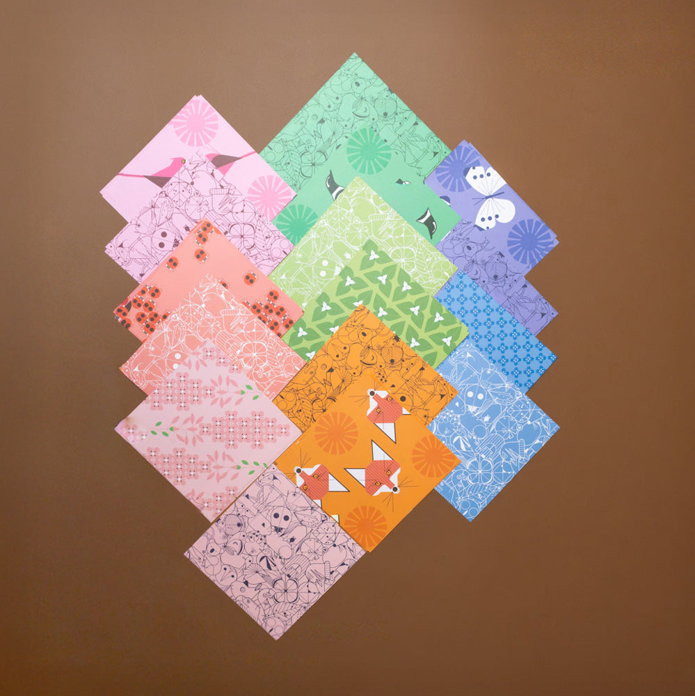 make-your-own-charley-harper-origami-animals-kit Collection of origami paper squares arranged in a diamond pattern on a brown background