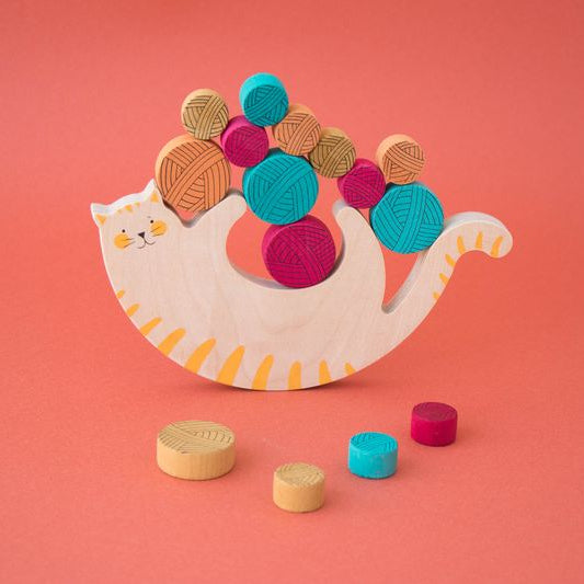 meow-balancing-game- Colorful wooden toy cat with geometric shapes on a pink background