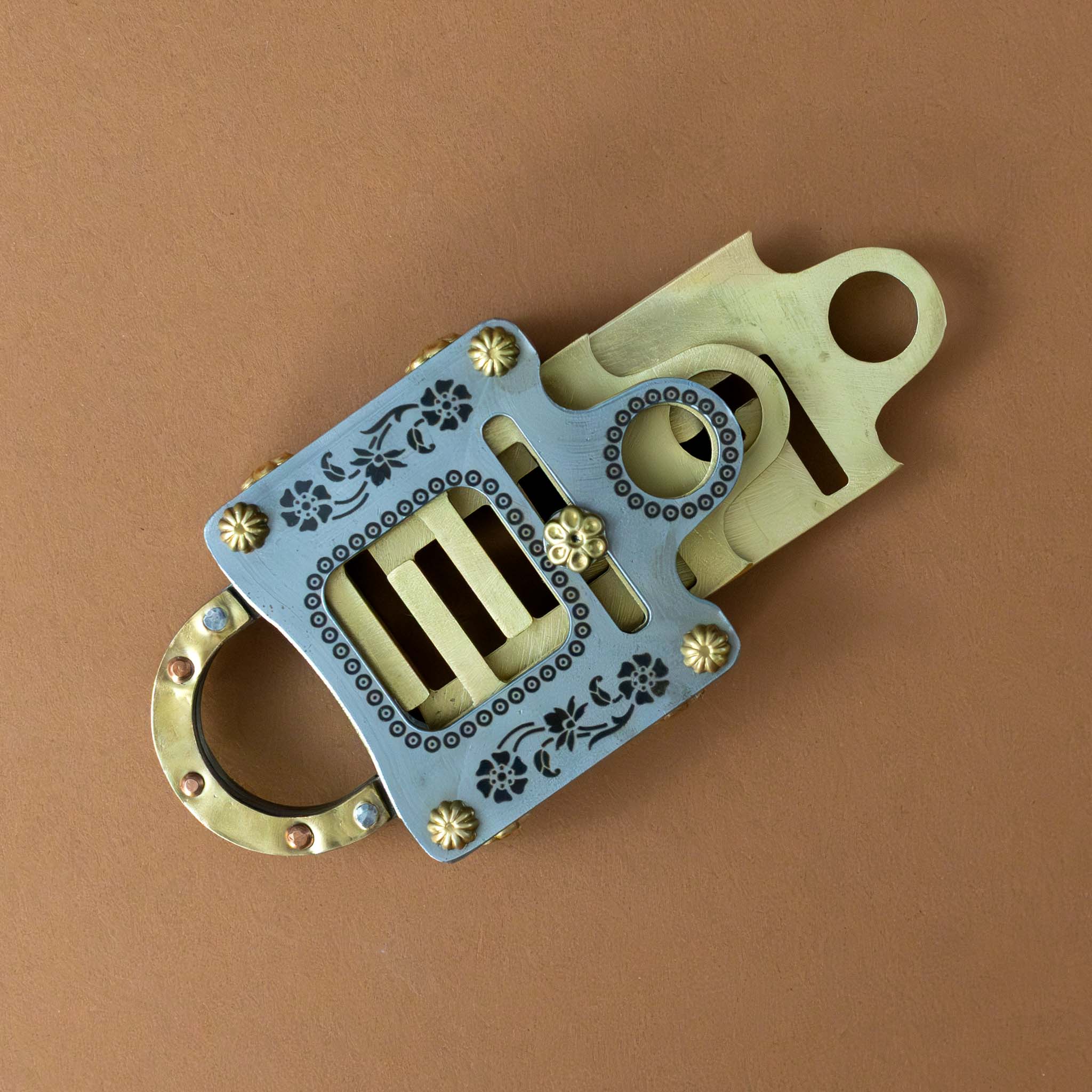 metal-un-locking-puzzle-brass-and-silver-colored-with-floral-detail-with-intricate-pieces-pulled-out