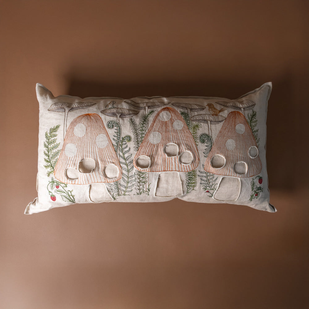 mushroom-forest-pocket-pillow Decorative pillow with mushroom design on a brown background