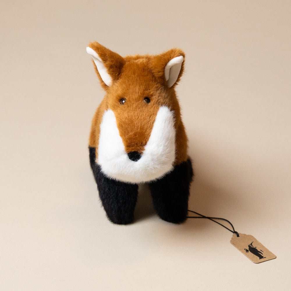 muzzle-frankie-fox-large Stuffed fox toy with a tag on a beige background