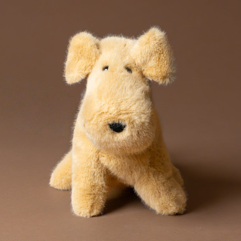 muzzle-tim-tan-pup Plush toy dog on a brown background