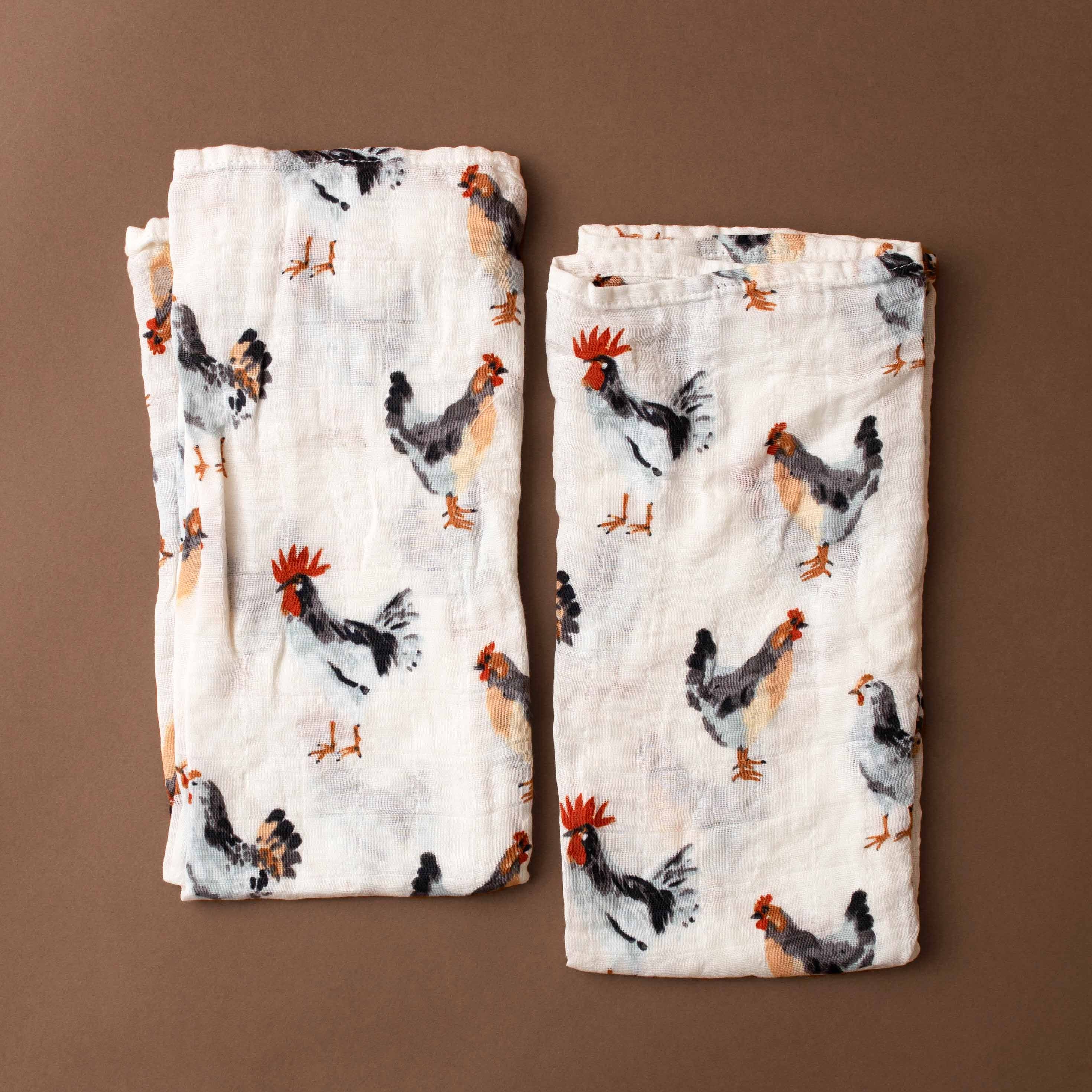 Two fabric organic-cotton-burpie-set-chickens with chicken pattern on a brown background