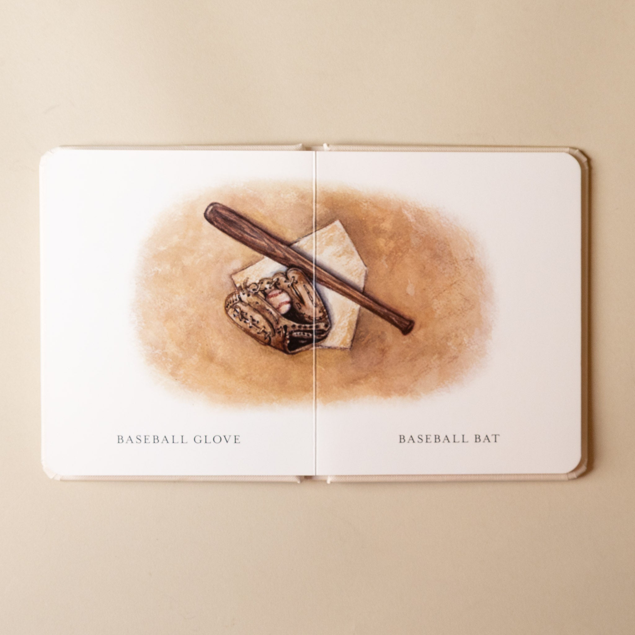 our-little-library-box-set--volume-iii-Open book with illustrations of a baseball glove and bat on a beige background