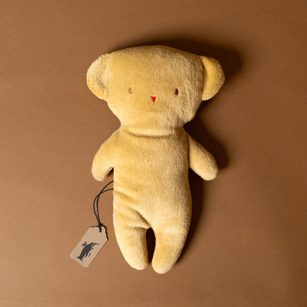 pancake-teddy bear stuffed-animal with a tag on a brown background