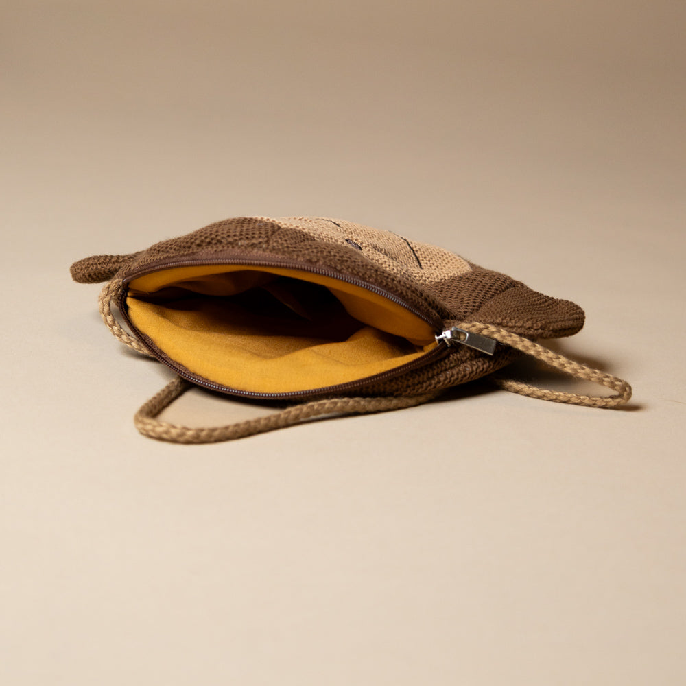 paulo-the-monkey-pocket-purse Brown knitted pouch with a zipper on a beige background