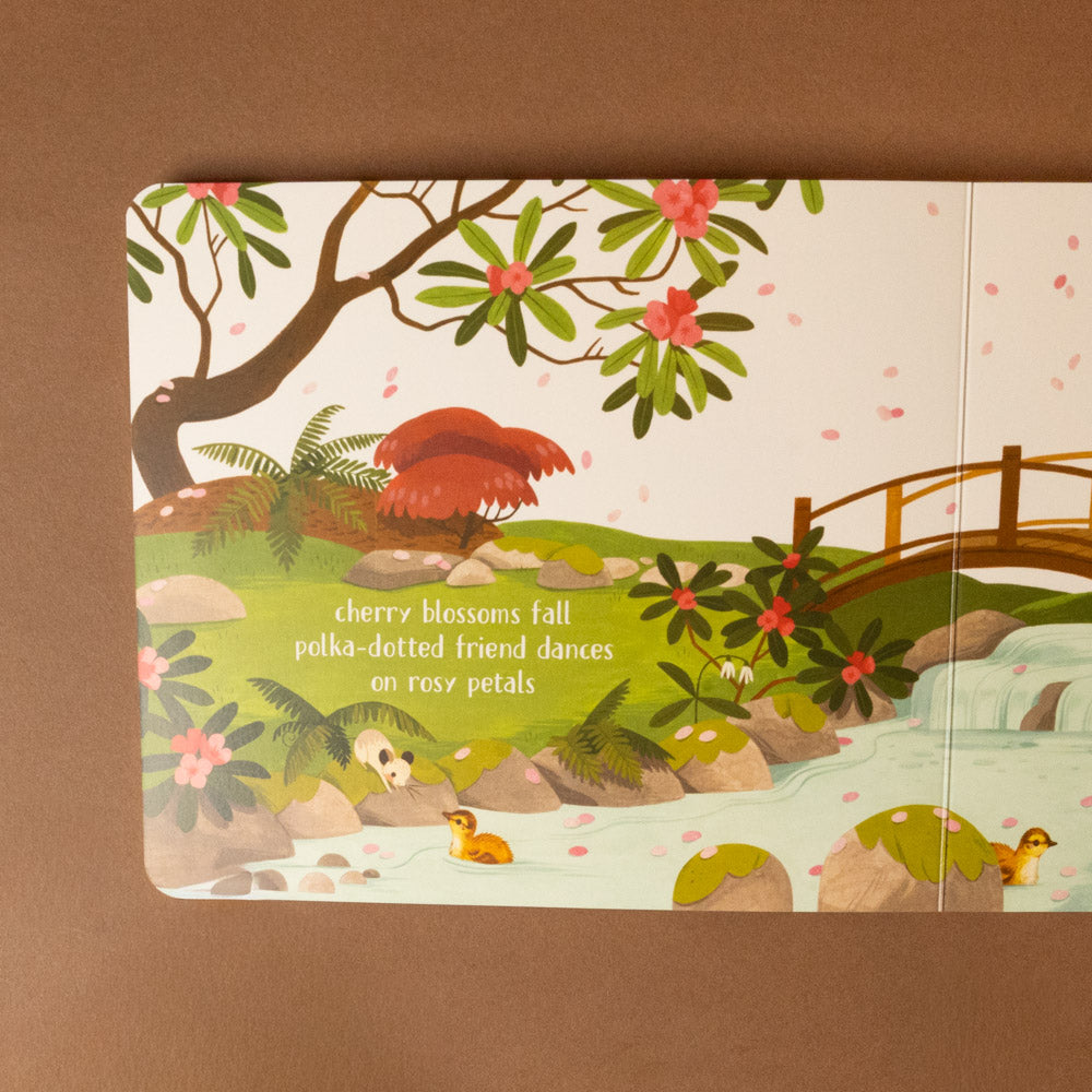 peek-a-boo-haiku-board-book Illustrated book page with cherry blossoms, ducks, and a bridge on a brown background