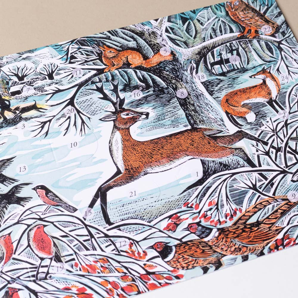 petit-advent-calendar winter-woodland Woodland scene with deer, foxes, and birds on a fabric or paper surface.