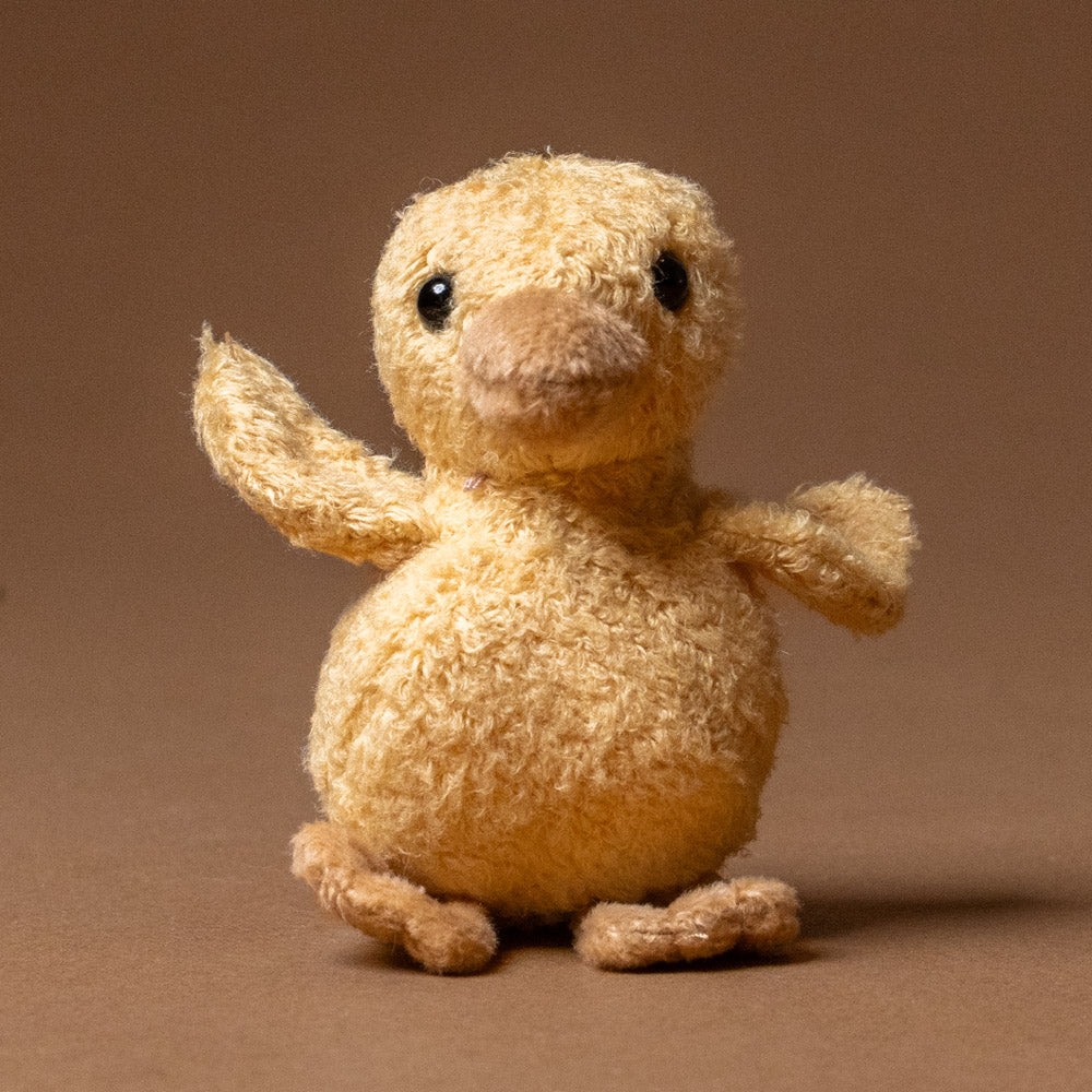 quack-the-duckling-awake stuffed animal toy on a brown background