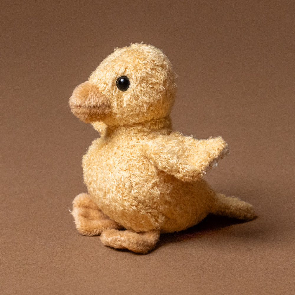 quack-the-duckling-awake Stuffed toy duck on a brown background