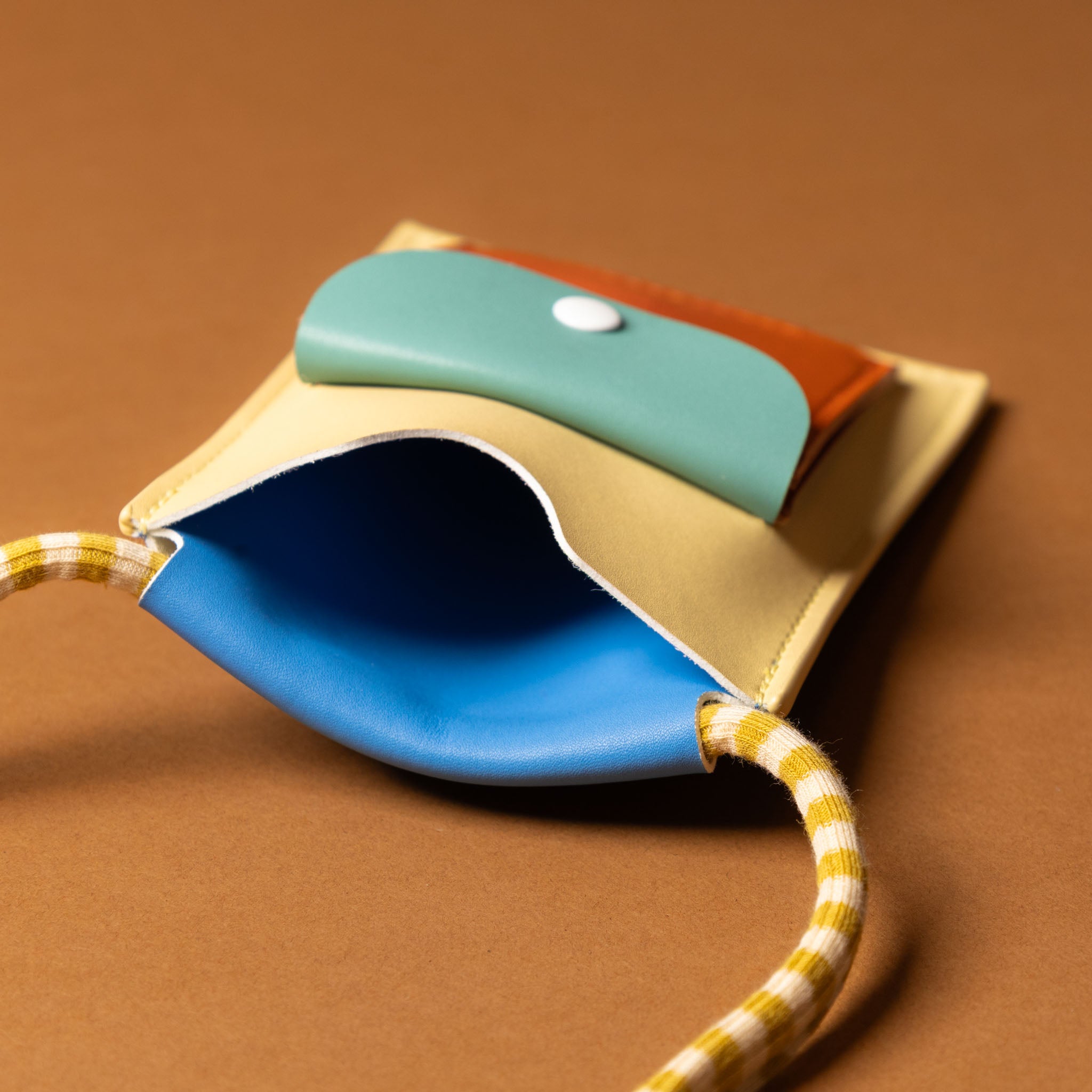 recycled-wonders-phone-pouch-open-sandy-beach-with-yellow-striped-strap