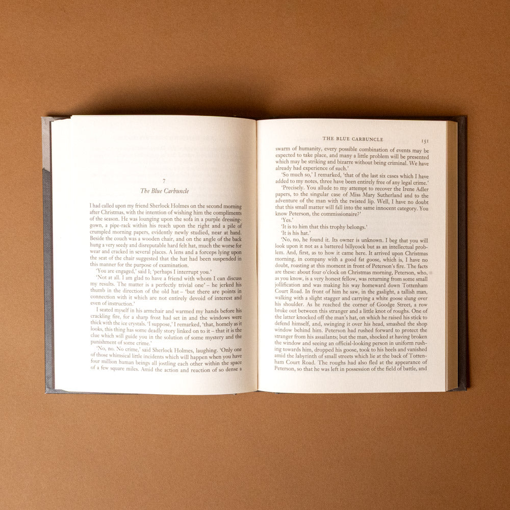 the-adventures-of-sherlock-holmes Open book on a brown background