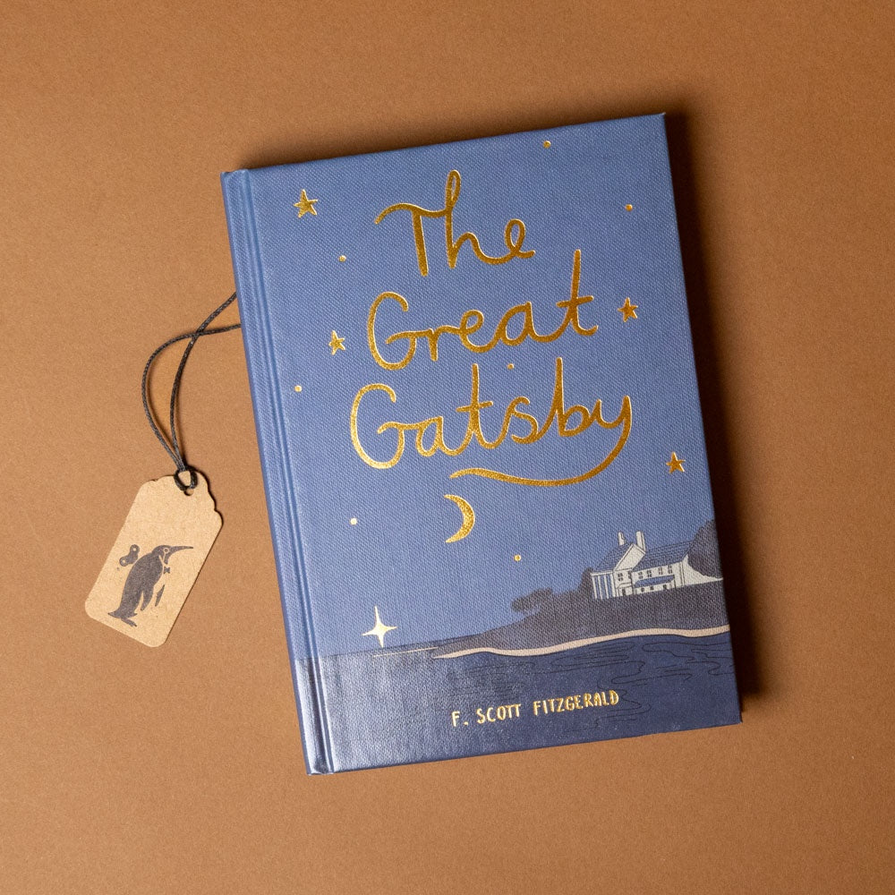Book titled 'The Great Gatsby' with a decorative tag on a brown background