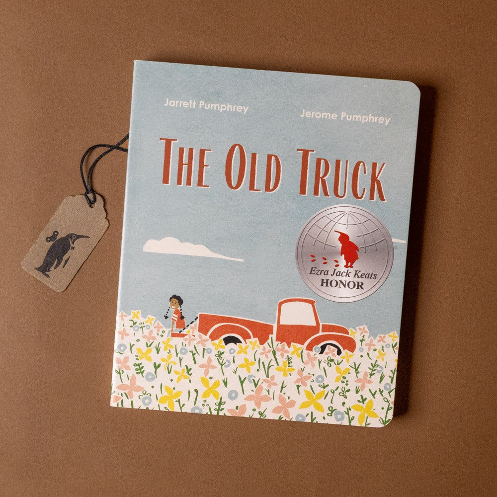 Book titled 'The Old Truck' with a tag on a brown background