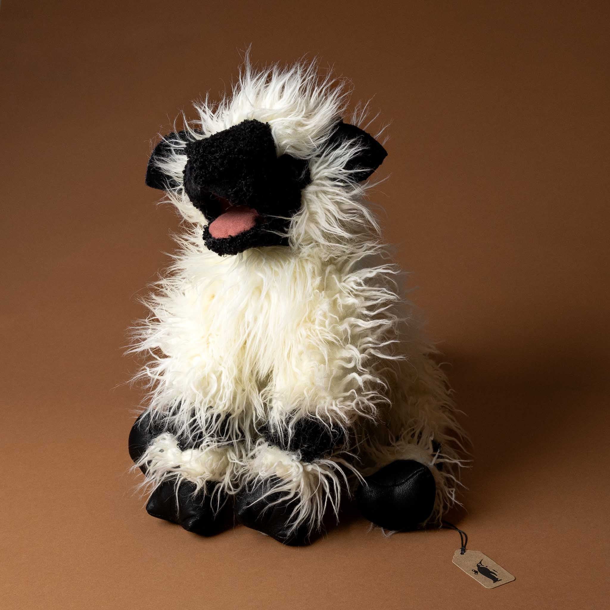 valais-black-nose-sheep-hand-puppet Plush toy sheep with black face and feet on a brown background
