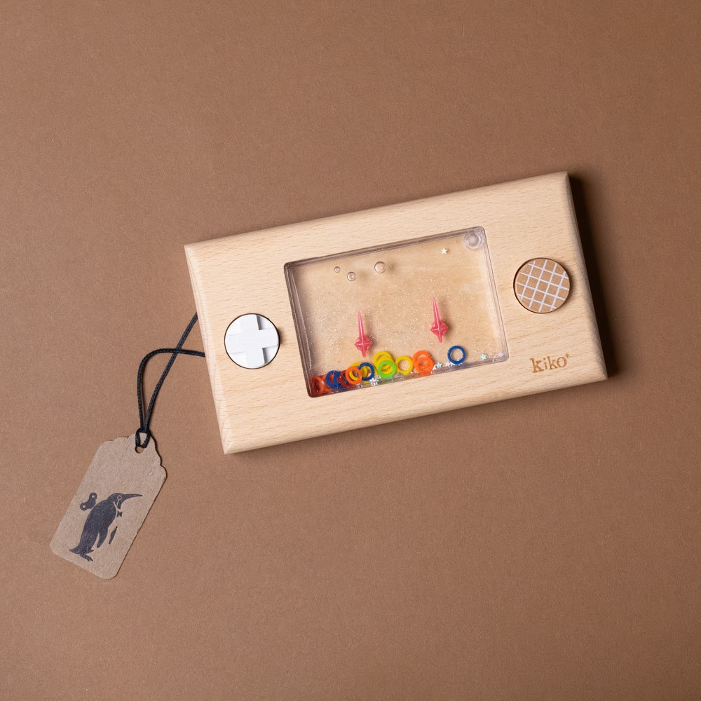 Wooden earring display with colorful earrings and a tag on a brown background