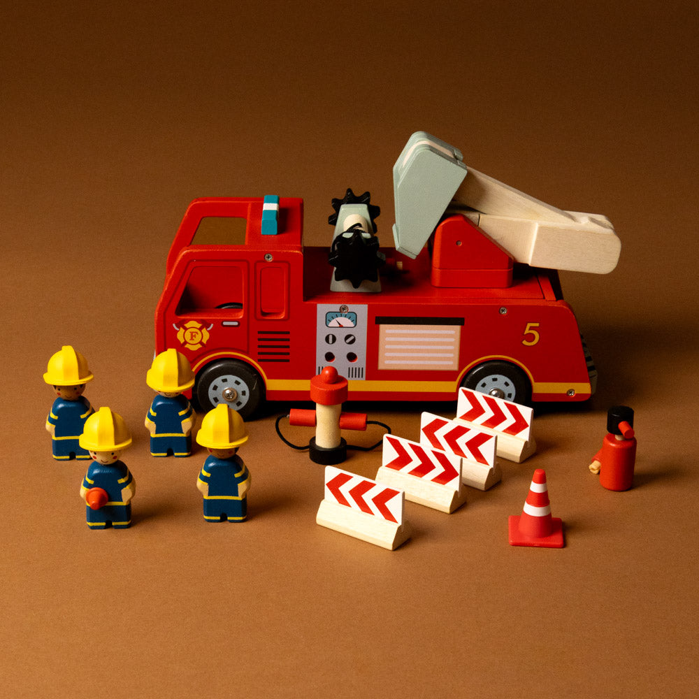 wooden-fire-engine-play-set Toy fire truck with firefighters and traffic cones on a brown background