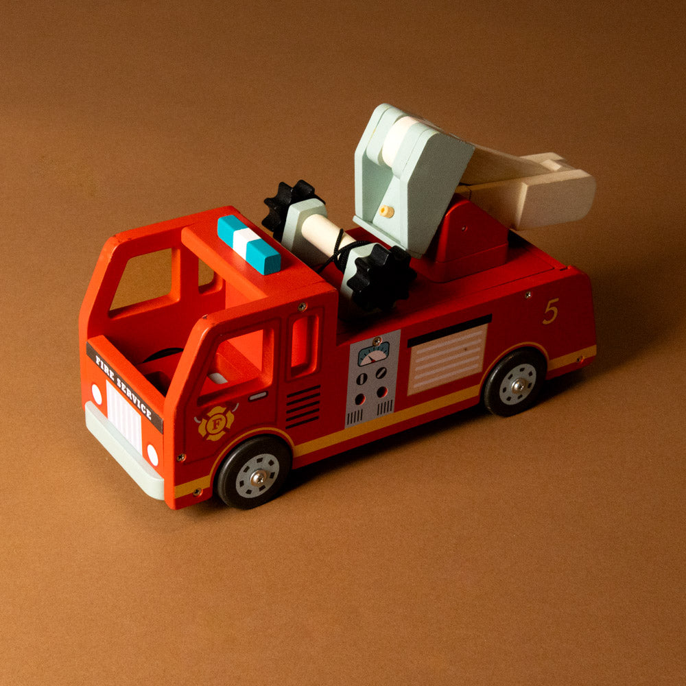 wooden-fire-engine-play-set Toy fire truck with a ladder on a brown background