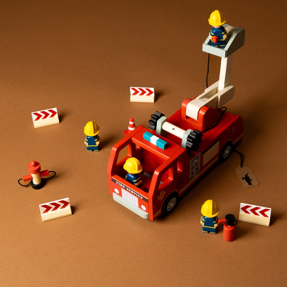 wooden-fire-engine-play-set -Toy fire truck with firefighters and equipment on a brown background