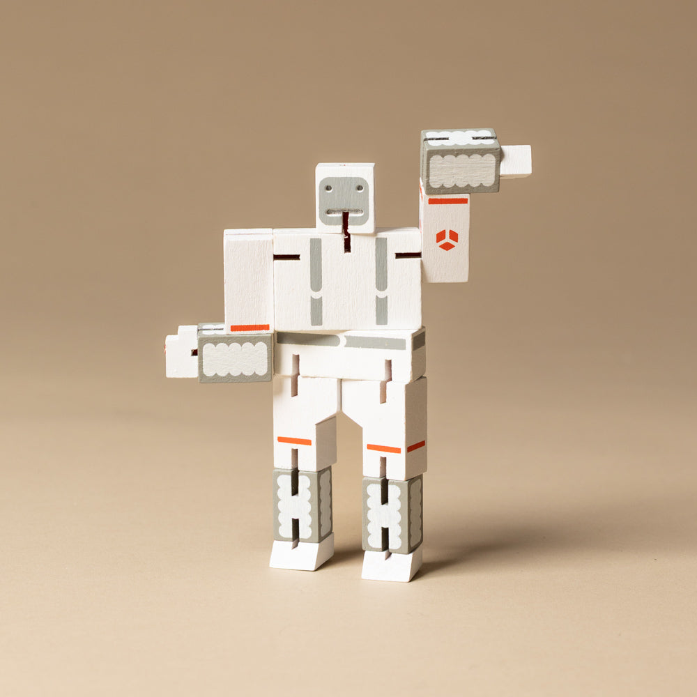 wooden-micro-cubebot-space-buddies-set White robot toy with orange accents on a beige background