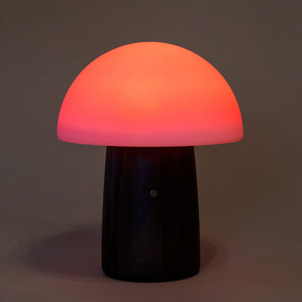wooden-mushroom-lamp-walnut with a red light on a dark background