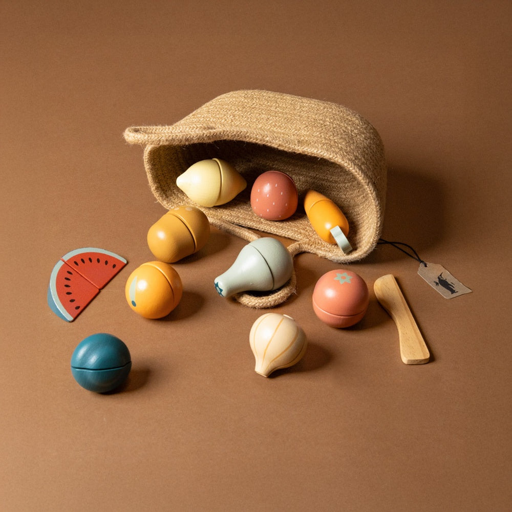 wooden-pretend-play-fruits-and-vegetables-to-cut-in-natural--shopping-tote Set of colorful wooden toys with a woven bag on a brown background