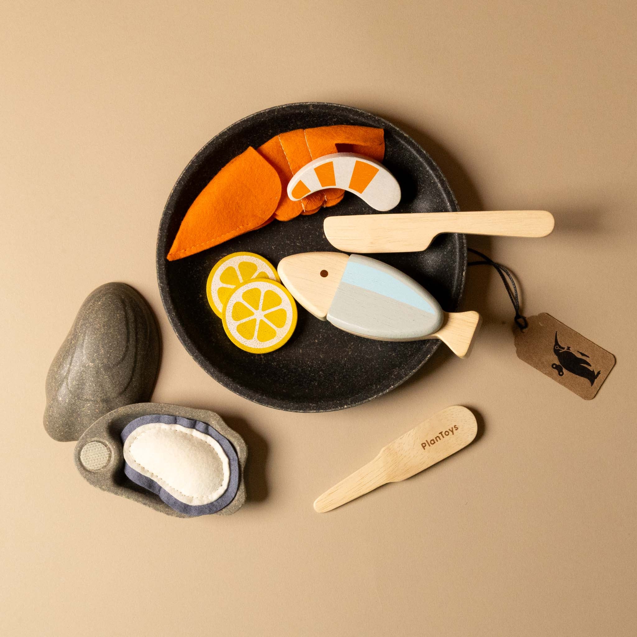 Set of wooden toy food items including a plate with fish, lemon slices, and carrots